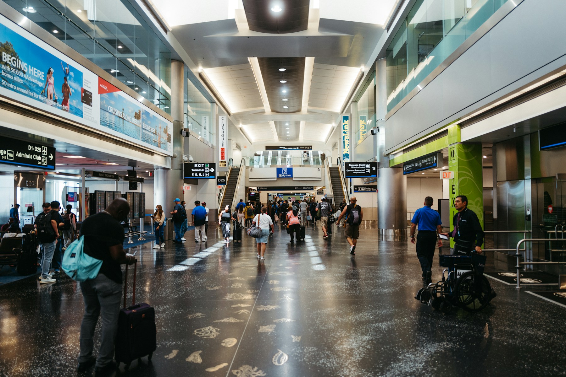 Saguão de aeroporto movimentado com passageiros em trânsito